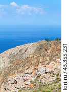 Summer landscape of Baikal Lake. A group of tourists travels along the rocky cape Sagan-Khushun or Three Brothers on Olkhon Island on sunny summer day. Стоковое фото, фотограф Виктория Катьянова / Фотобанк Лори