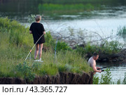 Russia, Tatarstan, June 12, 2024: summer vacation in nature. A couple fishing on the Kama River on a day off. Редакционное фото, фотограф Роман Дзюбало / Фотобанк Лори