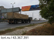 Военные грузовики КАМАЗ возвращаются с учений, движутся по улице города. Волгоград, 3-я Продольная улица, Россия. (2020 год). Редакционное фото, фотограф Андрей Цыганков / Фотобанк Лори