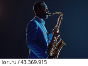 A jazzman plays a saxophone on a dark background. Стоковое AI-изображение, AI-художник Ярославский Максим / Фотобанк Лори