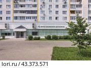 Вход в Центр московского долголетия в подмосковном Зеленограде. Зеленый газон с травой и кустами. Вывеска, кондиционеры на окнах центра и жилых квартир (2024 год). Редакционное фото, фотограф Сергей Никифоров-Гордеев / Фотобанк Лори