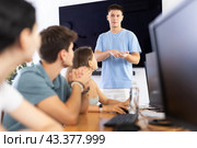 Young guy speaker stands in front of students and talks about use of artificial intelligence. Стоковое фото, фотограф Яков Филимонов / Фотобанк Лори