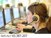 A woman is wearing headphones at a computer desk, surrounded by technology and peripherals. Стоковое AI-изображение, AI-художник Юрий Поздников / Фотобанк Лори