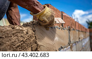 A working bricklayer lays bricks in the masonry. The construction concept. Close-up. Стоковое AI-изображение, AI-художник Ярославский Максим / Фотобанк Лори