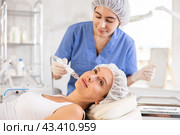Young woman cosmetologist doing cleansing procedure to young woman. Стоковое фото, фотограф Яков Филимонов / Фотобанк Лори