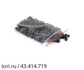 Spilled black grommets isolated on white background. Стоковое фото, фотограф Елена  Попкова / Фотобанк Лори