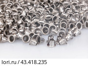 Spilled silver grommets isolated on white background. Стоковое фото, фотограф Елена  Попкова / Фотобанк Лори