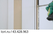 Sealing the opening between the door frame and the wall with mounting foam. Construction and repair. Installation and fastening of a wooden frame. Стоковое видео, видеограф Дмитрий Кобзев / Фотобанк Лори