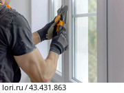 Window Measuring. Workman fixing, adjusting new plastic PVC window with white metal frame installing at modern house. Advertising. Typical installation of insulated glazing windows with uPVC frame. Стоковое AI-изображение, AI-художник Марина Демидюк / Фотобанк Лори