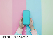 Modern smartphone held in a person's hand with a minimalistic digital art background. Стоковое AI-изображение, AI-художник Ярославский Максим / Фотобанк Лори