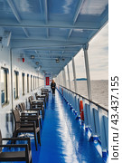 Deck of a ship, lake view, north sea from aboard a cruise ship. Unrecognizable silhouette of a walking and resting woman. The theme of traveling in northern regions and cold water spaces. Стоковое фото, фотограф Оксана Медведева / Фотобанк Лори