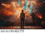 Musical concert or performance. In the center of the stage stands a musician with his back to the viewer, surrounded by spotlights and confetti flying in the air. Musical instruments, amplifiers and microphones are visible around the stage. The atmosphere is filled with energy and festive mood. Lighting effects and bright colors of confetti create the impression of a grand show. Стоковое AI-изображение, AI-художник Анна Кривицкая / Фотобанк Лори