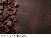 Chocolate bar and delicious chocolate on a brown backdrop. Composition of Broken chocolate bar and pieces texture background. Candy sweet dessert food. Different milk and dark chocolate, grated cocoa. Стоковое AI-изображение, AI-художник Марина Демидюк / Фотобанк Лори
