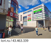 Торговый центр с рекламными вывесками и парковка, Москва, прохожие летом (2024 год). Редакционное фото, фотограф Ирина Терентьева / Фотобанк Лори