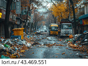 City ​​street littered with garbage and waste. There are overflowing trash cans and bags of garbage along the road. Two trucks are in the foreground, probably intended for garbage collection. The trees on both sides of the road have already lost their leaves, indicating autumn. The foliage on the trees and on the ground creates a contrast with the gray and gloomy surroundings. The buildings on both sides of the street look old and neglected. Стоковое AI-изображение, AI-художник Анна Кривицкая / Фотобанк Лори