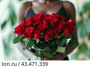 A beautiful bouquet of pastel rad roses in female hands. Work as a florist in a flower shop. Delivery of fresh cut flowers. European flower shop. Beautiful girl holding a bouquet of rad roses. Стоковое AI-изображение, AI-художник Евгений Демидюк / Фотобанк Лори