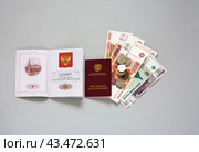 ANGARSK, IRKUTSK REGION, RUSSIA - July 04, 2024: Top view of Russian banknotes and coins, passport and red pension certificate on table. Сoncept of pension payments and indexation of pensions. Редакционное фото, фотограф Виктория Катьянова / Фотобанк Лори