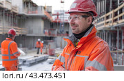 A man wearing a hard hat and safety glasses is at a construction site, prioritizing safety. Стоковое AI-изображение, AI-художник Юрий Поздников / Фотобанк Лори