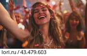 A woman is dancing joyfully at a party with her hands raised in the air, surrounded by a crowd. Стоковое AI-видео, аниматор Юрий Поздников / Фотобанк Лори
