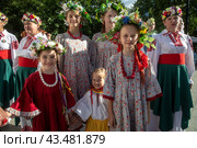 Девочки в традиционной белорусской одежде в венках из полевых цветов во время празднования белорусского праздника "Купалье" в парке "Останкино" города Москвы, Россия (2024 год). Редакционное фото, фотограф Николай Винокуров / Фотобанк Лори