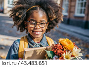 A pretty black African American woman in glasses with a bouquet of autumn flowers goes to school for the first time. A child with a school bag, a book and flowers. A child on a city street. Back to school. Стоковое AI-изображение, AI-художник Photojuli / Фотобанк Лори