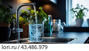 In the kitchen, water flows from a tap into a glass glass nearby, a stream of water fills the cup. Стоковое AI-изображение, AI-художник Ярославский Максим / Фотобанк Лори