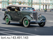 Ретро автомобиль Ford V8 Deluxe Phaeton на Дворцовой площади солнечным днем. Ежегодный парад ретротранспорта. Санкт-Петербург (2017 год). Редакционное фото, фотограф Виктор Карасев / Фотобанк Лори