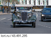 Ретро автомобиль Ford V8 Deluxe Phaeton на городской улице солнечным днем. Вид спереди (2017 год). Редакционное фото, фотограф Виктор Карасев / Фотобанк Лори