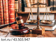 Justice and the law. A wooden hammer, books and scales on the table. The court session. Стоковое AI-изображение, AI-художник Photojuli / Фотобанк Лори