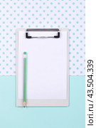 Top view of white clipboard with empty page on white and blue background. Стоковое фото, фотограф Юлия Трикашная / Фотобанк Лори