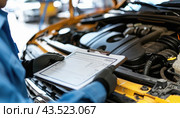 An automotive mechanic examines a cars engine and records observations on a clipboard. Стоковое AI-изображение, AI-художник Юрий Поздников / Фотобанк Лори
