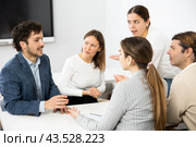 Emotional language teacher telling interesting stories to adult attentive students during class break in auditory. Стоковое фото, фотограф Яков Филимонов / Фотобанк Лори