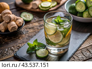 Detoxifying water with cucumber, lemon, lime, ginger and mint for a healthy diet. Стоковое AI-изображение, AI-художник Photojuli / Фотобанк Лори