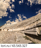 Roman Theatre in Amman, Jordan -- theatre was built the reign of Antonius Pius (138-161 CE), the large and steeply raked structure could seat about 6000 people. Against the sky with clouds (2016 год). Стоковое фото, фотограф Владимир Журавлев / Фотобанк Лори