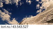 Roman Theatre in Amman, Jordan -- theatre was built the reign of Antonius Pius (138-161 CE), the large and steeply raked structure could seat about 6000 people. Against the sky with clouds (2016 год). Стоковое фото, фотограф Владимир Журавлев / Фотобанк Лори