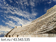 Roman Theatre in Amman, Jordan -- theatre was built the reign of Antonius Pius (138-161 CE), the large and steeply raked structure could seat about 6000 people. Against the sky with clouds (2016 год). Стоковое фото, фотограф Владимир Журавлев / Фотобанк Лори