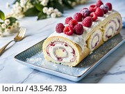 Swiss sponge roll with raspberries, a delicious fruit and cream dessert filled with cream cheese, decorated with fresh raspberries. Стоковое AI-изображение, AI-художник Photojuli / Фотобанк Лори