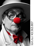 Close-up selective color portrait of sad clown. An elderly man in a white coat and hat. Стоковое фото, фотограф Сергей Пристяжнюк (Serg Zastavkin) / Фотобанк Лори