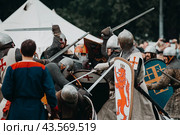 Реконструкторы в костюмах средневековых рыцарей бьются на мечах. Исторический фестиваль «Времена и эпохи», посвящённый реконструкции исторических событий. Парк Коломенское, Москва, 2019. Редакционное фото, фотограф KOSIM / Фотобанк Лори