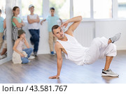 Hip-hop instructor demonstrating dance moves to tweens in studio. Стоковое фото, фотограф Яков Филимонов / Фотобанк Лори