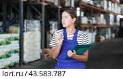 In warehouse of store, girl checks quantity of goods and receipt documents for products. Стоковое видео, видеограф Яков Филимонов / Фотобанк Лори