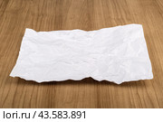 Crumpled sheet of white office paper on a wooden table. Стоковое фото, фотограф Сергей Долгов / Фотобанк Лори