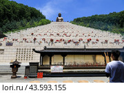Golden Giant Buddha in Dunhua City, China.  Гигантский бронзовый Будда  на горе Людиншань, в городе Дунхуа, провинция Цзилинь, Китай (2024 год). Редакционное фото, фотограф Римма Тельнова / Фотобанк Лори