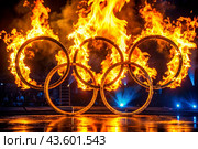 A fire show. The burning rings of the Olympic Sports Games. Стоковое AI-изображение, AI-художник Photojuli / Фотобанк Лори