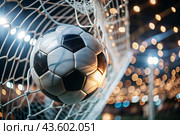 Goal. A soccer ball in the goal net, against a background of sparkling lights and a blurred background. Стоковое AI-изображение, AI-художник Photojuli / Фотобанк Лори