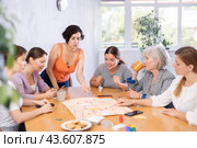 Young female moderator throws stones and determines order of parties in board game. Стоковое фото, фотограф Яков Филимонов / Фотобанк Лори