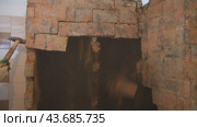 Dismantling an old brick oven. Black soot inside the furnace wells. Dirty and dusty work during house renovation. Breaking with a hammer. Стоковое видео, видеограф Дмитрий Кобзев / Фотобанк Лори