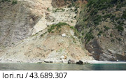 Vezirova Ratkova Plaza, Budva, Montenegro 07.22.24 Cave Hills, inaccessible rocks. Flysch, marine sedimentary rocks, lithological layers. Adriatic Mediterranean sea. People relaxing on rocky beach (2024 год). Редакционное видео, видеограф Юлия Петровская / Фотобанк Лори