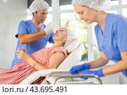 Professional cosmetologist doing botulinum injections in forehead to elderly woman. Стоковое фото, фотограф Яков Филимонов / Фотобанк Лори