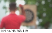 A man is playing darts outside, out of focus. Recreation outdoor sports. Стоковая анимация, аниматор Скрипачев Антон / Фотобанк Лори